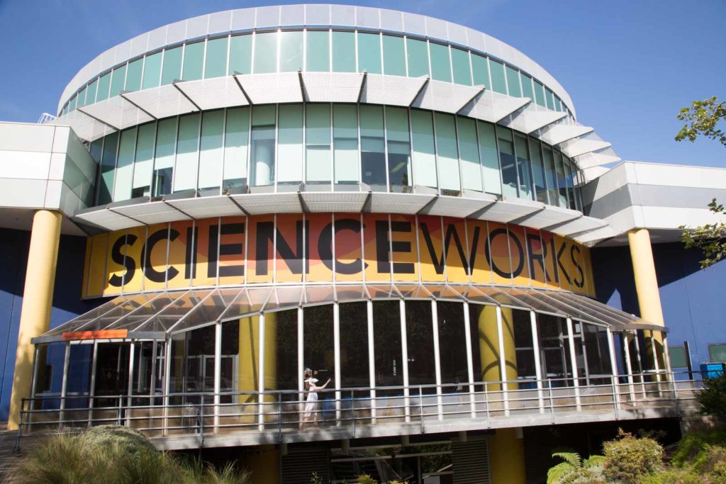 Image of the ScienceWorks building. The building is a round shape with an orange central point and large black text that reads ‘ScienceWorks’.