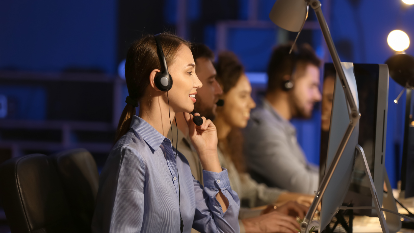A customer service team working at computers with headsets, providing support in an after hours call centre.